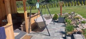 a porch with a swing in a garden at Dębowa Chata in Jasło