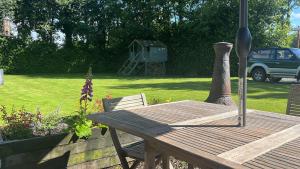 a wooden table and chair with a bird house in a yard at Serenity Cottage in Newpark