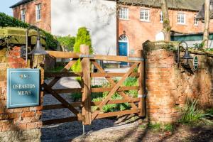 a wooden gate with a sign in front of a house at Stable Yard Cottage in Osmaston