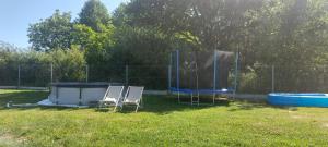 a couple of chairs and a trampoline in a yard at Dębowa Chata in Jasło