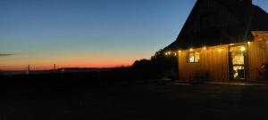 a house with lights on the side of it at sunset at Dębowa Chata in Jasło