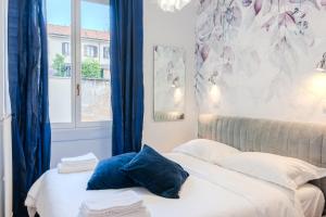 a bedroom with a bed with blue pillows and a window at BM7-Design&Style in Milan