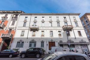 a white building with cars parked in front of it at BM7-Design&Style in Milan