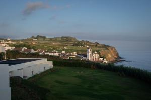 a building on a hill next to the ocean at Sul Villas & Spa - Azores in Lagoa