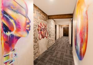a hallway with colorful paintings on the walls at Bresoles Hotel in Montreal +79 photos