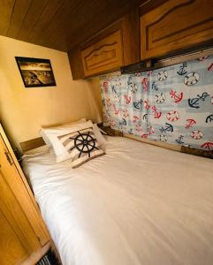 a bed in a small room with white sheets and pillows at Dębowy zakątek camping in Pobierowo +7 photos