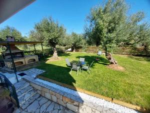 a garden with a table and chairs and a grill at Olive Harmony House in Ariokhórion