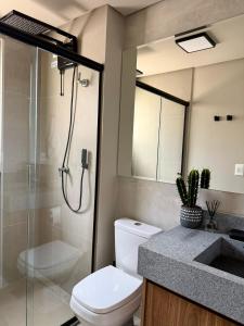 a bathroom with a shower and a toilet and a sink at Studio moderno e confortável no Marista in Goiânia