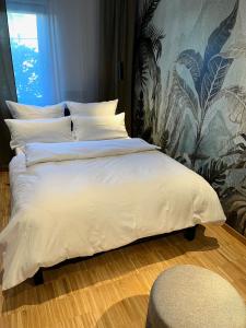 a bed with white sheets and pillows in a bedroom at Green Nights Hotel in Dettelbach