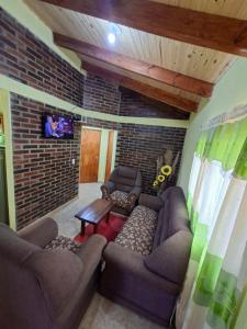 a living room with two couches and a tv at Su Escapada Perfecta in Ruiz de Montoya