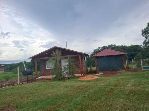 a small house in a yard with a grass field at Su Escapada Perfecta in Ruiz de Montoya