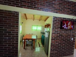 a kitchen and dining room with a table and a brick wall at Su Escapada Perfecta in Ruiz de Montoya