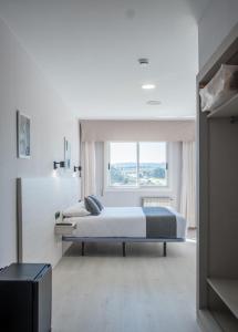 ein Schlafzimmer mit zwei Betten und einem großen Fenster in der Unterkunft Alda Arteixo in Vilarrodis + 84 Fotos