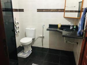 a bathroom with a toilet and a sink at Suíte Rodoviária no centro de Arraial in Arraial do Cabo +9 photos