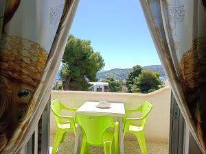 a table and chairs on a balcony with a view at Eri Studios in Agia Marina Aegina