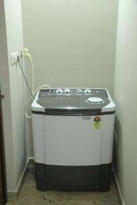 a small stove in a corner of a room at NR HEAVENZ Near Rajagiri Hospital in Alwaye