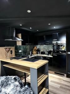 a kitchen with black cabinets and a wooden counter top at WW Luxury Cottage in Müschenbach