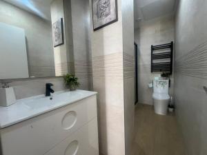 a bathroom with a white sink and a toilet at Cozy apartment in Leganés in Leganés