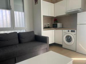 a living room with a couch and a washing machine at Cozy apartment in Leganés in Leganés