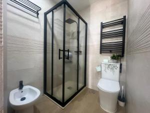 a bathroom with a shower and a toilet and a sink at Cozy apartment in Leganés in Leganés