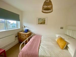 a bedroom with a bed and a desk and a window at Modern 2-Bed Apartment with Off-Street Parking in Chiswick in London