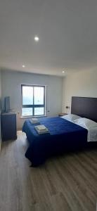 a bedroom with a large bed and a window at Beachfront Amazing Location - 19th Hole in Ponta Delgada