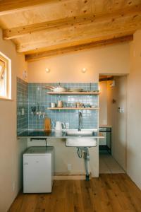 a kitchen with a sink and blue tiles at Ocean view cabin in Nanjo +25 photos