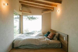 a bed in a room with a large window at Ocean view cabin in Nanjo