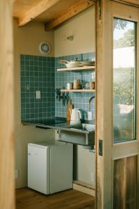 a kitchen with a sink and green tiles at Ocean view cabin in Nanjo