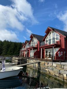 a boat in the water in front of a house at Heggøy rorbuer in Heggøyni