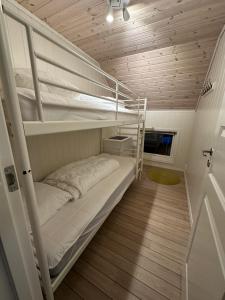 a room with two bunk beds in a house at Heggøy rorbuer in Heggøyni