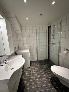 a bathroom with two sinks and a shower and a toilet at Heggøy rorbuer in Heggøyni +20 photos