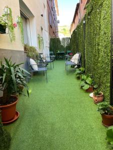 a balcony with green flooring and chairs and plants at Los Cucos in Cabezuela del Valle