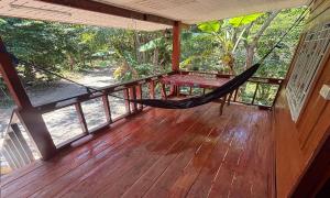 a hammock on the porch of a house at Duangkeaw Simple House in Phra Ae beach
