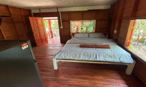 a bedroom with a bed in a wooden house at Duangkeaw Simple House in Phra Ae beach