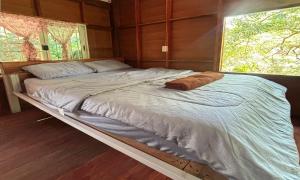 a large bed in a room with a large window at Duangkeaw Simple House in Phra Ae beach