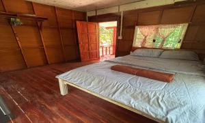 a bedroom with a bed in a wooden room at Duangkeaw Simple House in Phra Ae beach +12 photos
