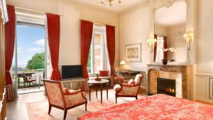 a bedroom with a fireplace and a living room with a television at Villa Rothschild, Autograph Collection in Königstein im Taunus