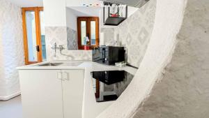 a white kitchen with a sink and a microwave at La Grotta in Vernazza