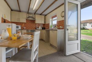 a kitchen with a wooden table and a dining room at Landscove Chalet 23 in Brixham +10 photos