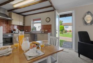 a kitchen with a wooden table with food on it at Landscove Chalet 23 in Brixham