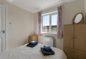 a bedroom with a bed with two towels on it at Landscove Chalet 23 in Brixham