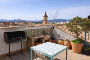 a patio with a table and a grill on a roof at la Alhábega in Villena