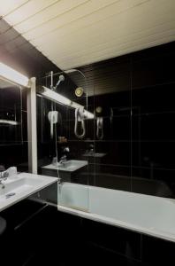 a bathroom with a shower and a sink and a tub at Hôtel Du Leman in Paris