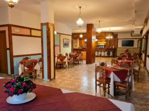 a dining room with tables and chairs in a restaurant at Garni Pirata in Cavareno