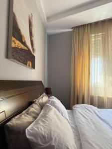 a hotel room with two beds and a window at Prishtina Center Apartment, 100m from Skanderbeg Square in Prishtinë