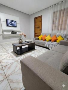 a living room with two couches and a tv at Casa Vivah in Lençóis