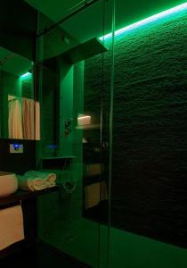 un bagno verde con doccia e porta in vetro di Residenza Monfy a Roma