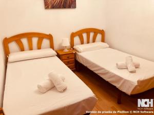 two beds in a room with towels on them at Amapola 1 in Soria +10 photos