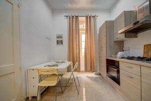 a kitchen with a small table and chairs in a room at Suite Victory Authentic Maltese Duplex in Birgu in Birgu